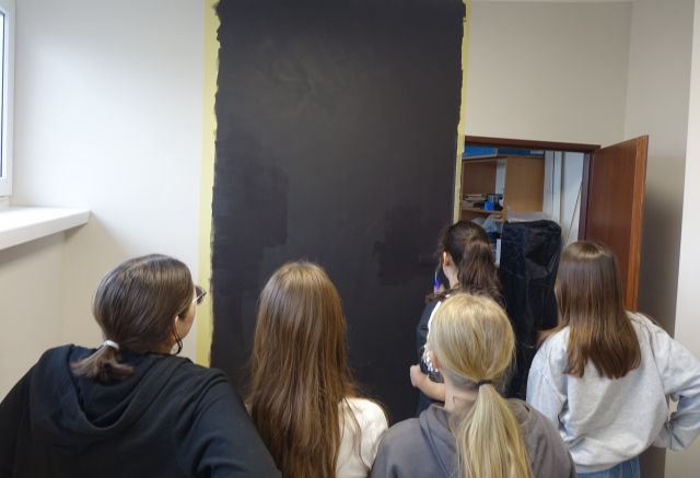 młodzież maluje ściankę farbą czarną tablicową