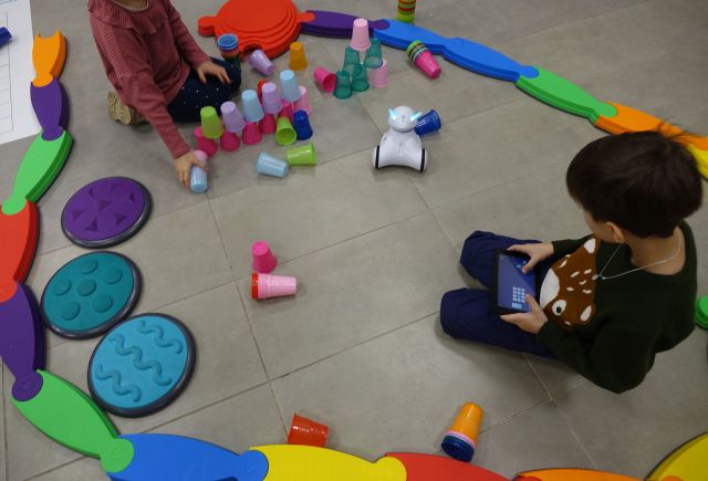 chłopiec steruje robotrm Photon, który jedzie po torze przeszkód