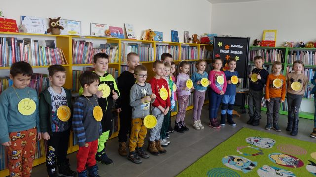 przedszkolaki pozują do zdjęcia z wykonanymi ptrzez siebie żółtymi medalami