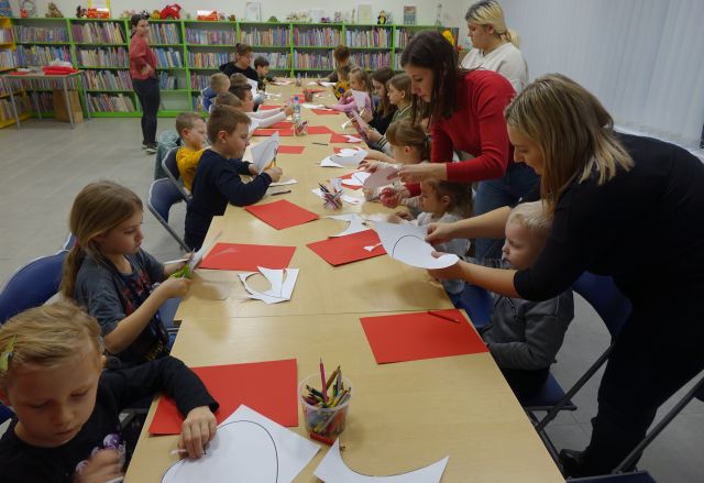 uczestnicy warsztatów robią laurki z czerwonych materiałów