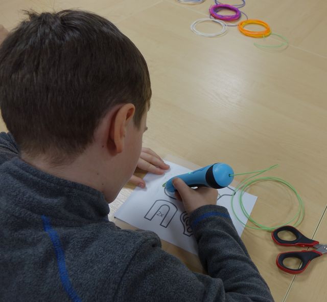 chłopiec pisze długopisem 3D