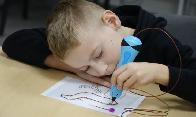 chłopiec drukuje długopisem 3D