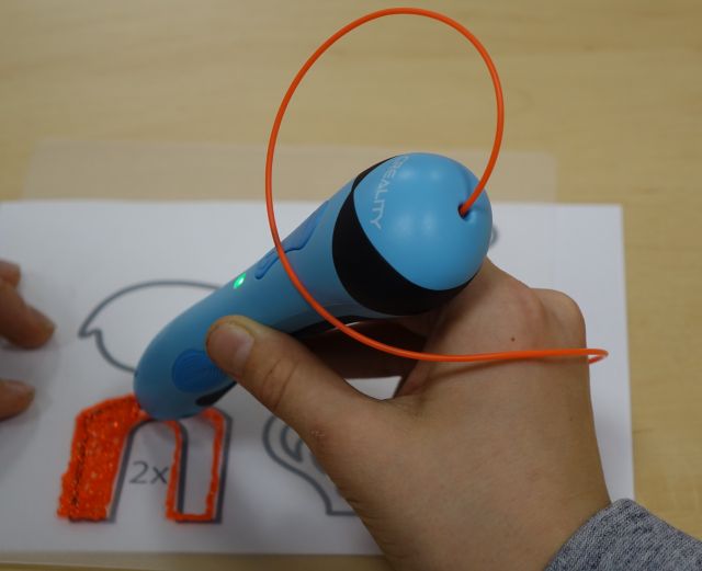 dziecko drukuje długopisem 3D