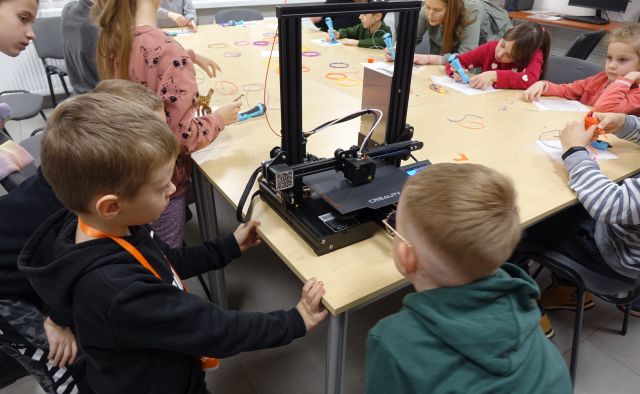 dzieci patrzą na drukarkę 3D
