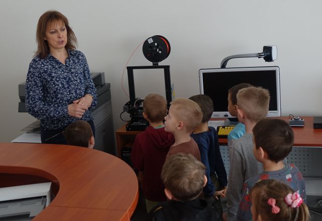 dyrektorka biblioteki pokazuje przedszkolakom drukarkę 3d