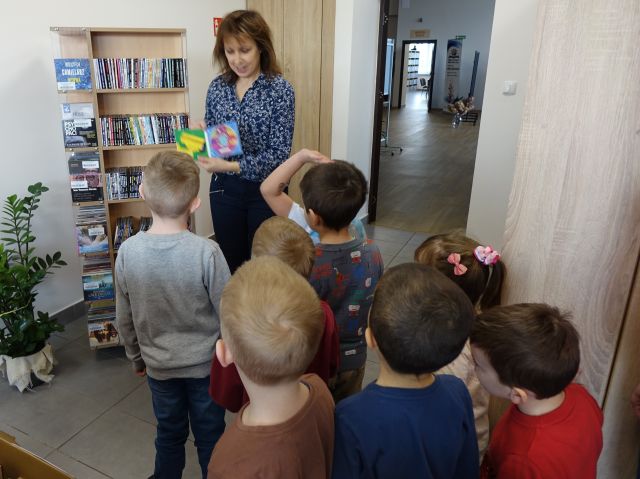 dyrektorka biblioteki pokazuje przedszkolakom audiobooki