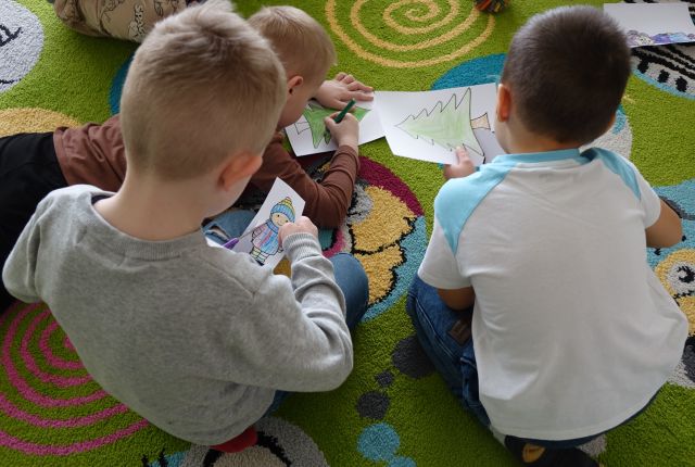 dzieci wycinają pokolorowane przez siebie obrazki