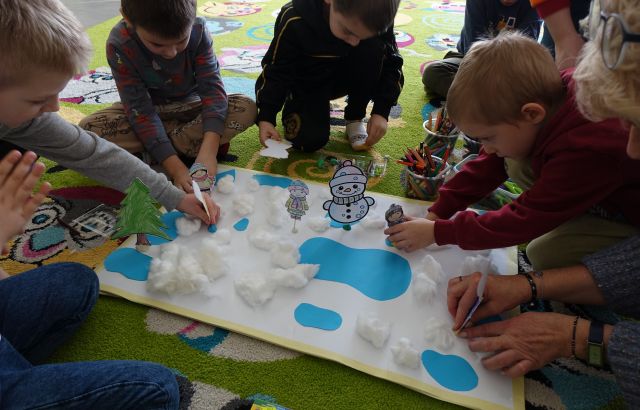 przedszkolaki układają zimową makietę