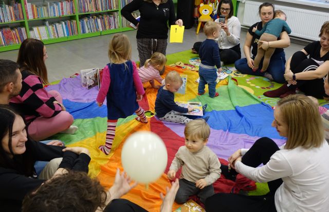 dzieci z rodzicami bawią się na chuście animacyjnej