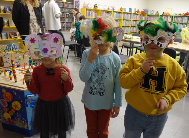 3 dzieci prezentuje wykonane przez siebie maski karnawałowe