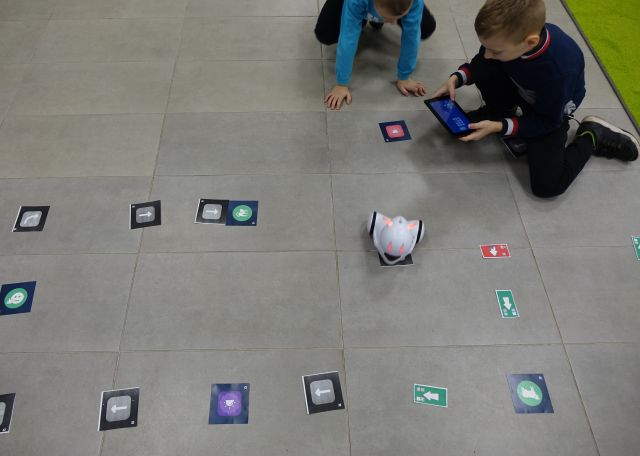 dwóch chłopców steruje przy pomocy tabletów robotami Photon