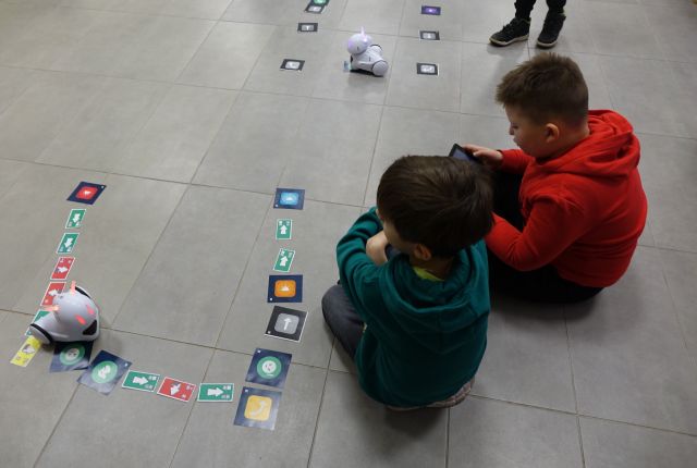 dwóch chłopców steruje przy pomocy tabletów robotami Photon