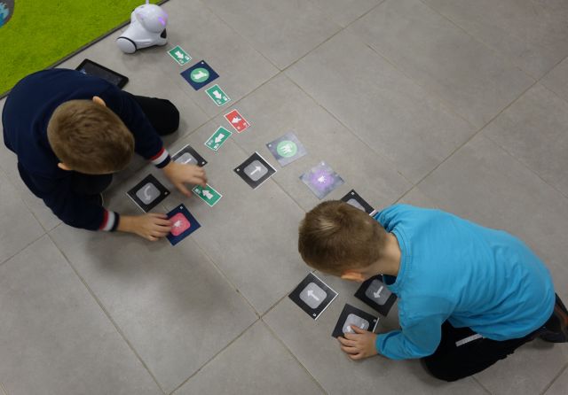 dwóch chłopców steruje przy pomocy tabletów robotami Photon