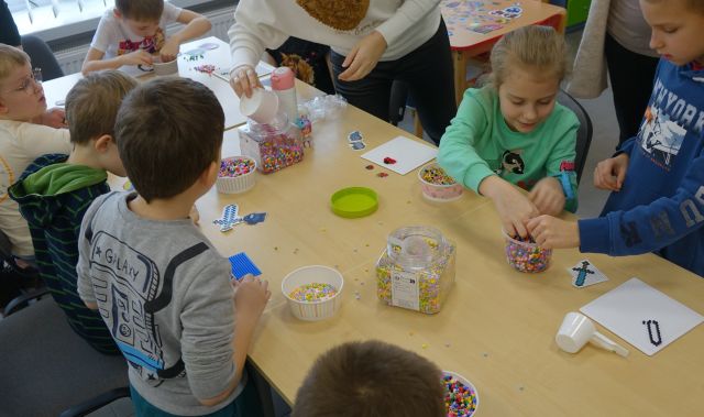 dzieci układają figurki z koralików