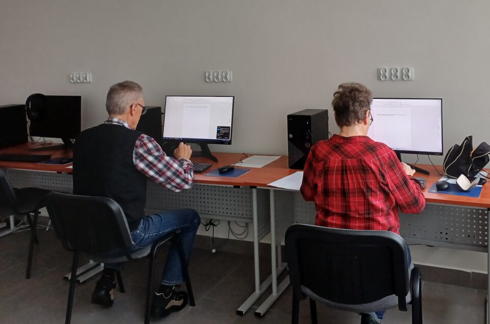 kobieta i mężczyzna siedzą przed komputerami