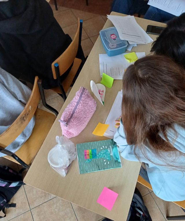 dwie dziewczyny piszą na kolorowych karteczkach