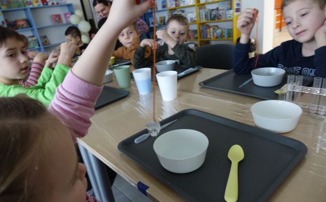 dzieci robią lód w miseczkach, na sznureczkach