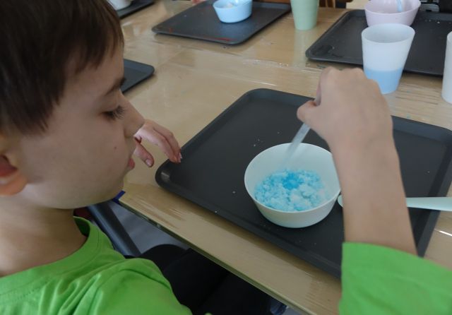 chłopiec miesza masę tworząc slima