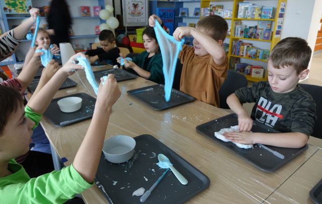 dzieci pokazują ciągnące się slimy