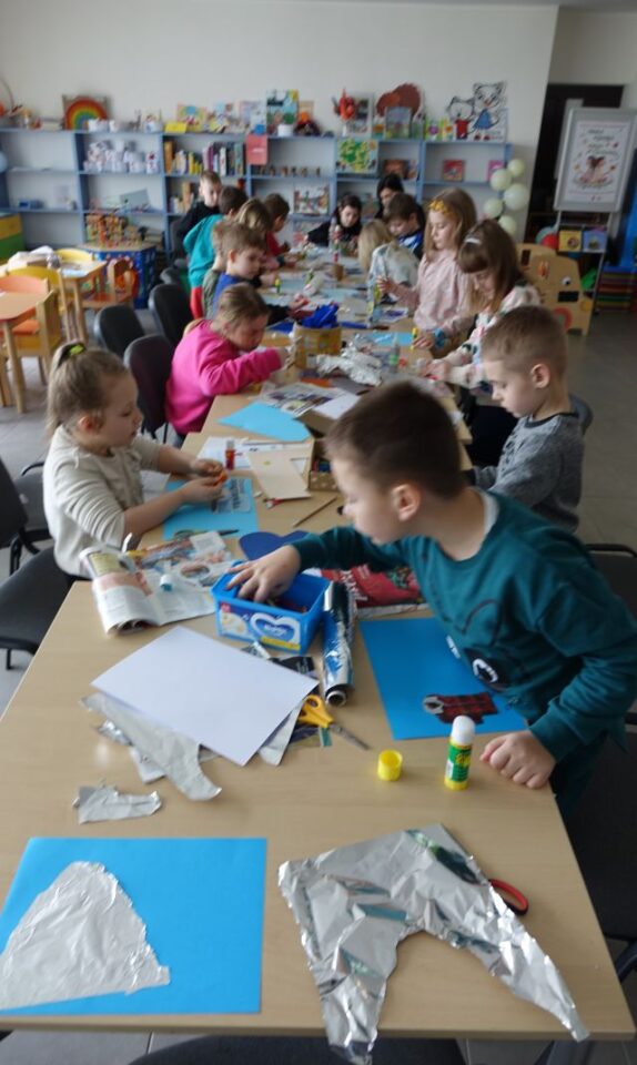 dzieci wykonują kolaż z różnych materiałów