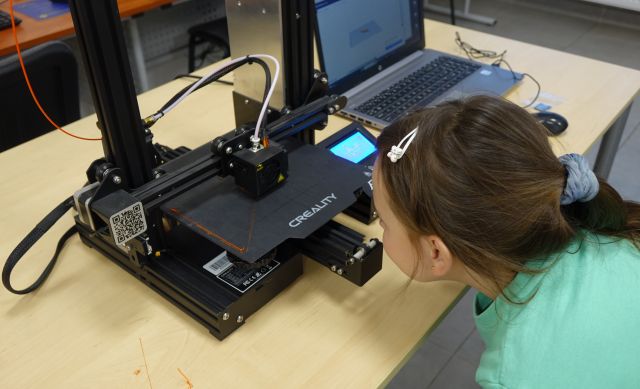 dziewczynka przygląda się drukarce 3d