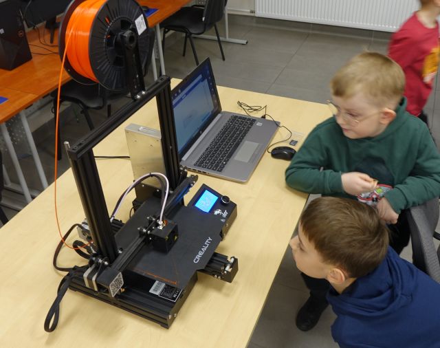 dwóch chłopców przygląda się drukarce 3d