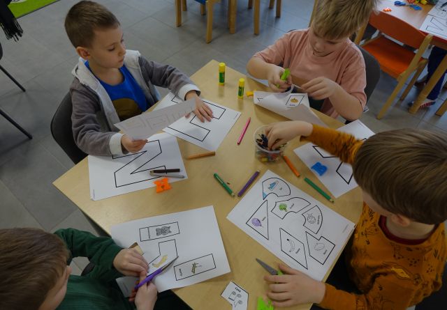 dzieci kolorują i wycinają literki