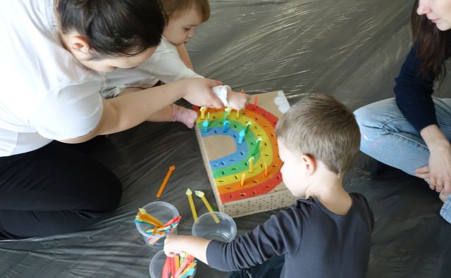 mały chłopiec i mama robią tęczę z patyczków