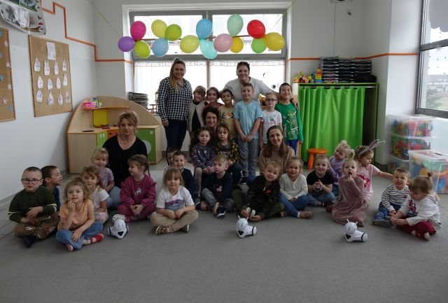 przedszkoalki pozują do zdjęcia z nauczycielkami i robotami Photon