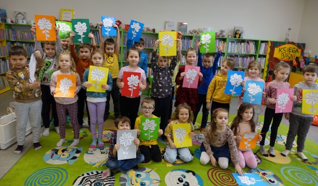 przedszkolaki pozują do zdjęcia z wykonanymi przez siebie pracami - kwiatkami z dabrymi zasadami