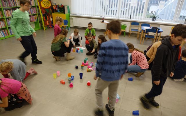 dzieci układają kolorowe kubeczki