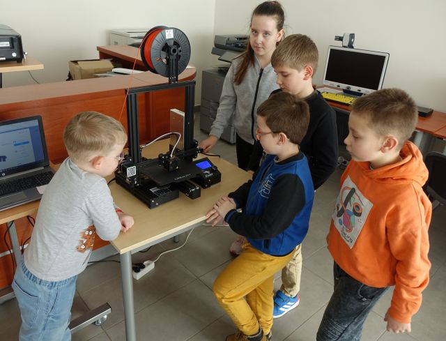 dzieci patrzą na drukarkę 3d