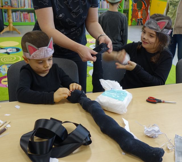 dzieci tworzą przebranie kota, wypychają czarny ogon watą