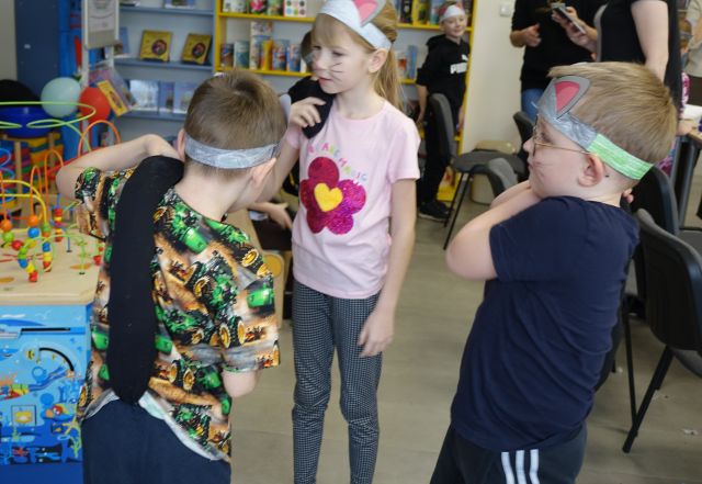 dzieci prezentują części przebrania za kota