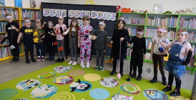 dzieci uczestniczące w warsztatach pozują do zdjęcia w przebraniach kotów