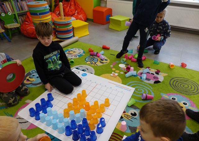 dzieci układają kolorowe kubeczki według zakodowanych obrazków