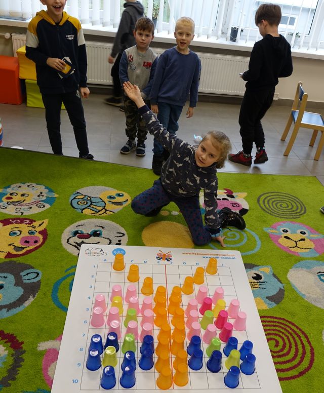 dzieci układają kolorowe kubeczki