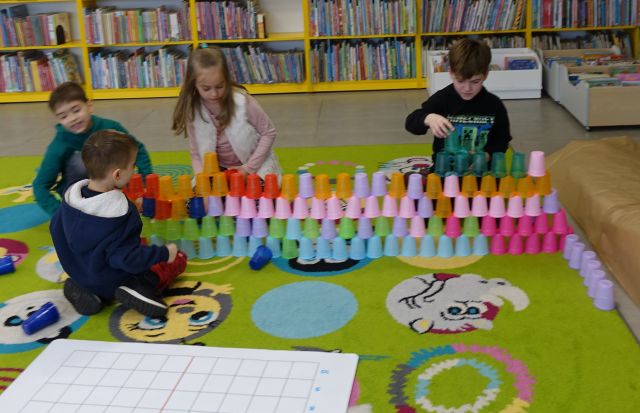 dzieci układają kolorowe kubeczki według wzoru