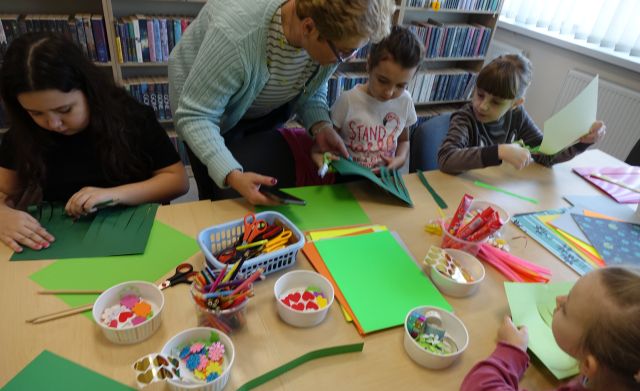 dzieci i rodzice robią kwiatki z kolorowych kartek