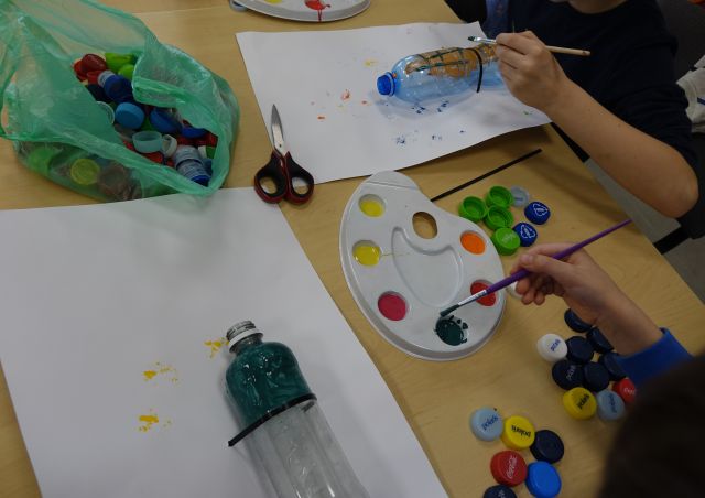 plastikowa butelka częściowo pomalowana i farbki na paletach