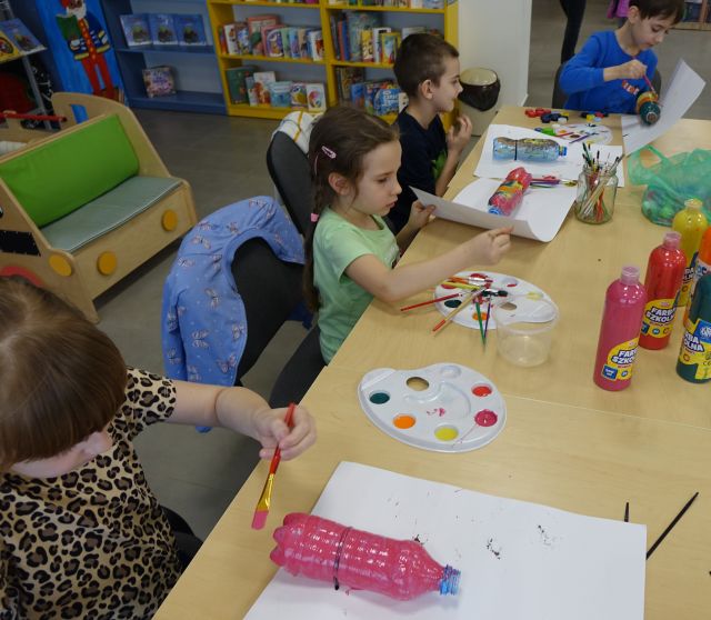 dzieci malują plastikowe butelki farbkami