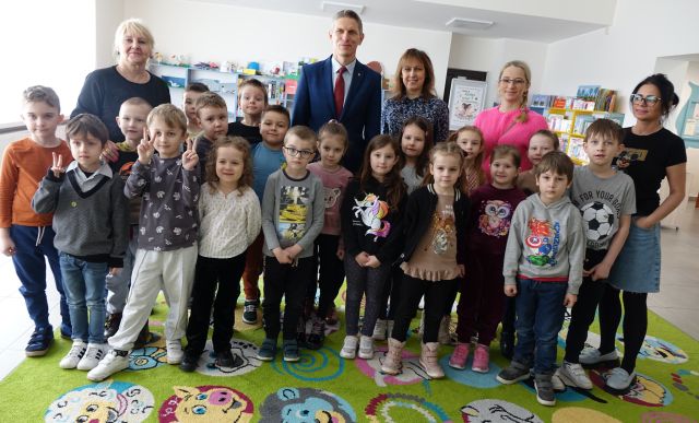 przedszkolaki pozują do zdjęcia z bibliotekarkami, burmistrzem i przedszkolankami