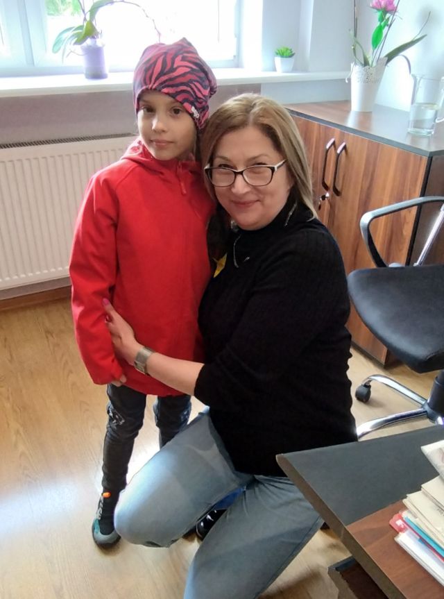 na zdjęciu kobieta przytulająca dziewczynkę