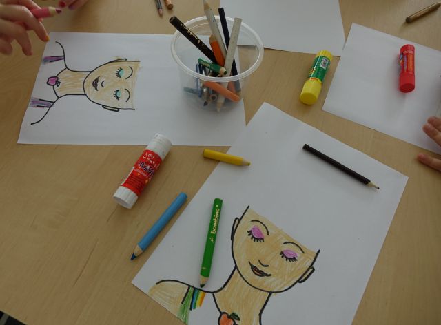 na zdjęciu pokolorowene profile damskich głów, kredki i kleje