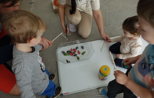 małe dzieci wyławiają zabawkowe rybki z miski