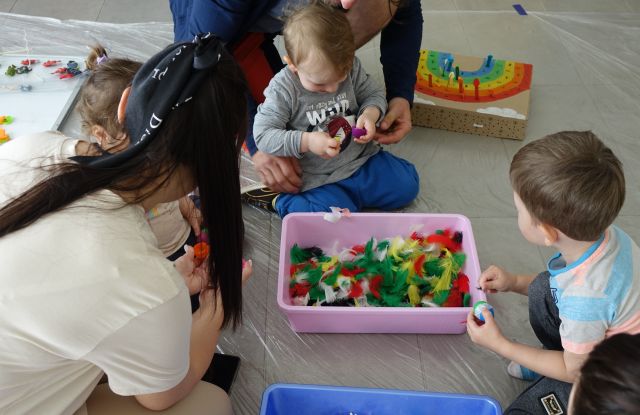 małe dzieci wyławiają jajeczka schowane w kolorowych piórkach 