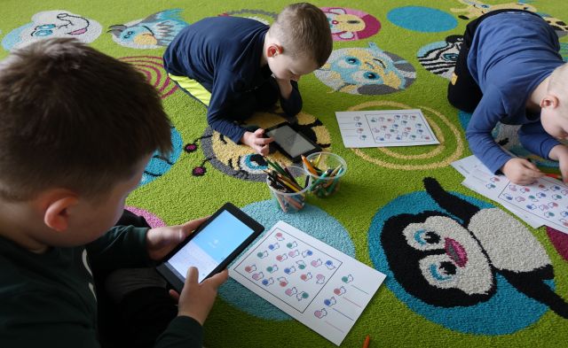 dzieci na dywanie zakodoane obrazki wprowadzają do tabletów