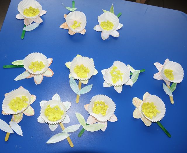 żonkile z papieru na niebieskim stole