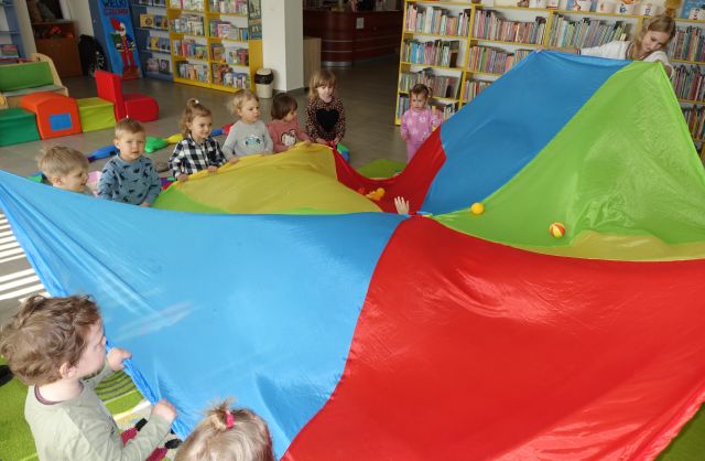 małe dzieci trzymają kolorową chustę animacyjną