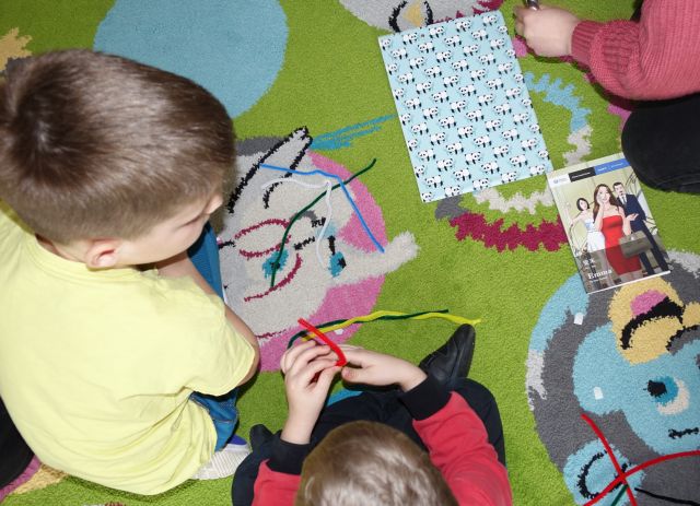 dzieci układają ze sznurków litery chińskie